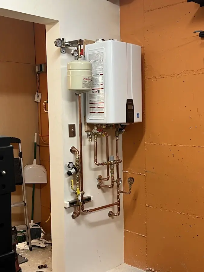 Plumbing technician inspecting water heater connections in Paradise